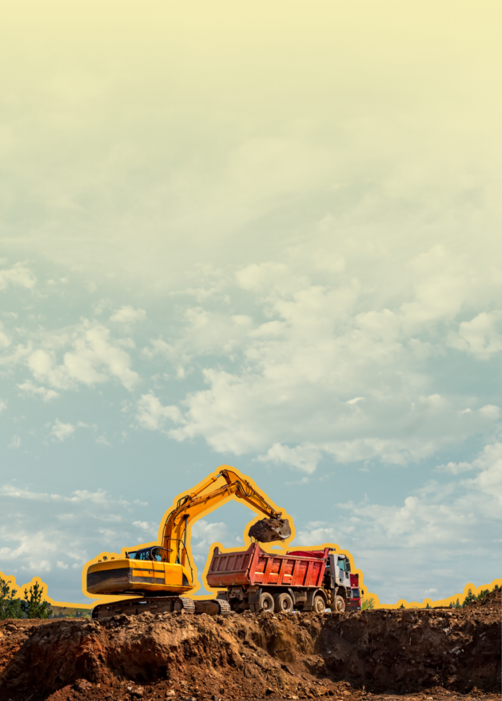 Yellow excavator scooping dirt into a red dump truck at a construction site under a cloudy blue sky